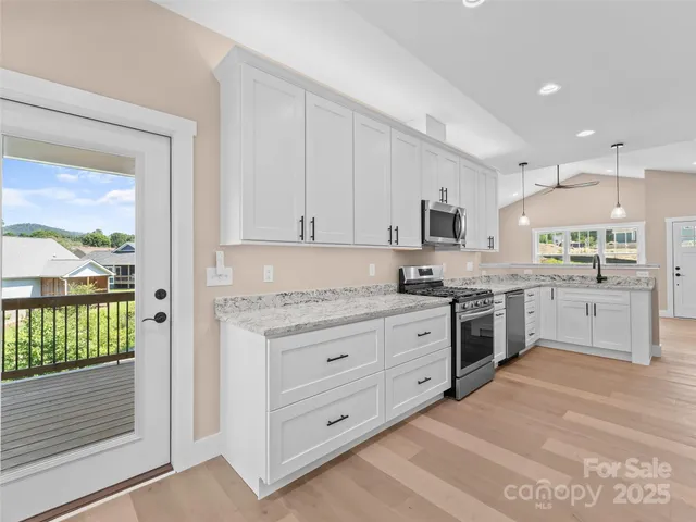 a kitchen with granite countertop white cabinets and appliances