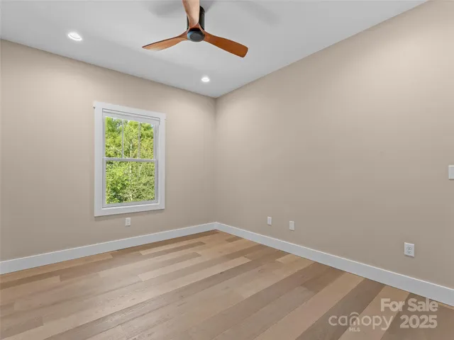 an empty room with a window and a ceiling fan