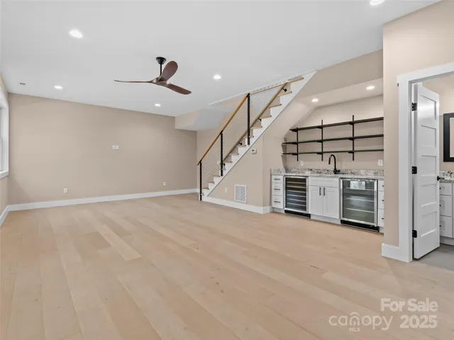 an empty room with wooden floor and staircase