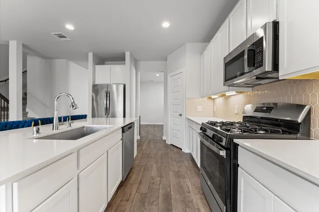 a kitchen with stainless steel appliances a sink stove and microwave