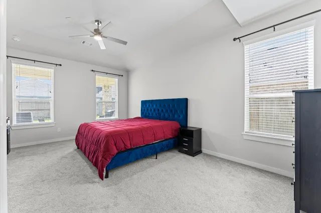 a spacious bedroom with a bed and a window