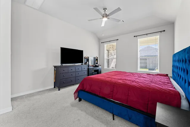 a spacious bedroom with a bed and a flat screen tv