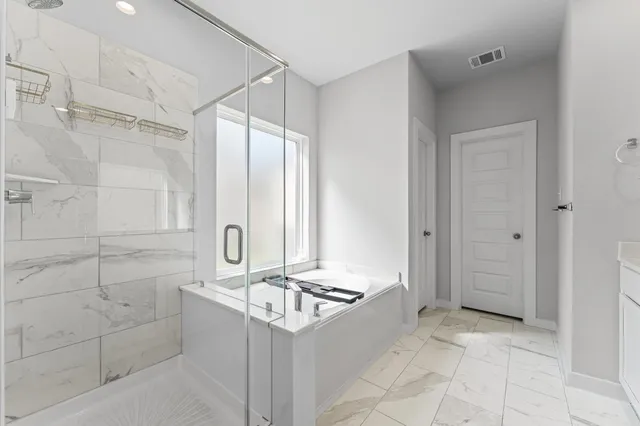 a bathroom with a granite countertop sink a mirror and a bathtub