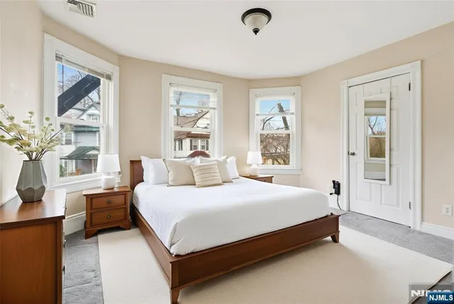 a large bedroom with a bed and wooden floor