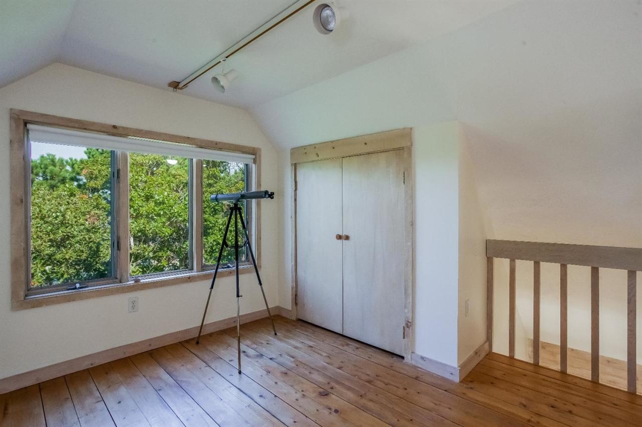 21 Metacomet Road Mashpee, MA 02649 - Photo 10 of 30 a view of an empty room with wooden floor and a window