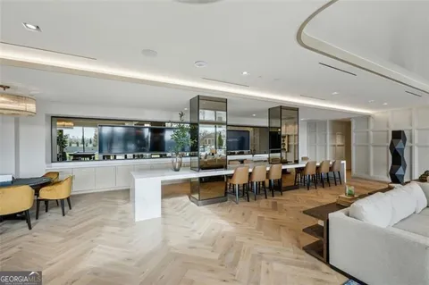 a room with lots of tables a large window and chairs