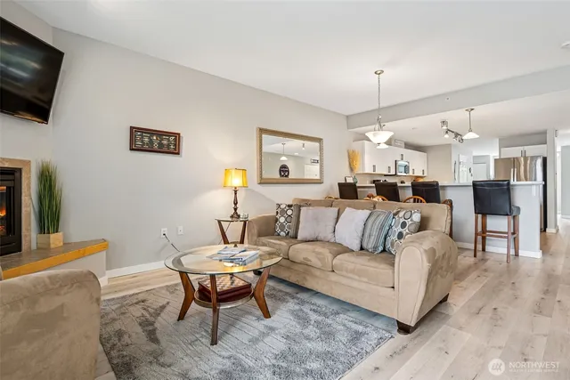 a living room with furniture a flat screen tv and kitchen view