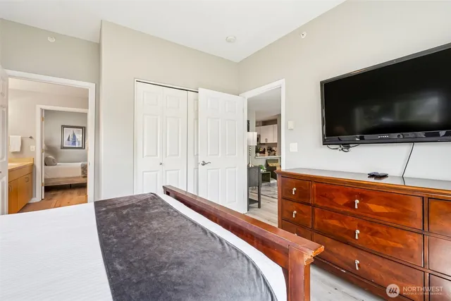 a bedroom with a bed and a dresser next to a window