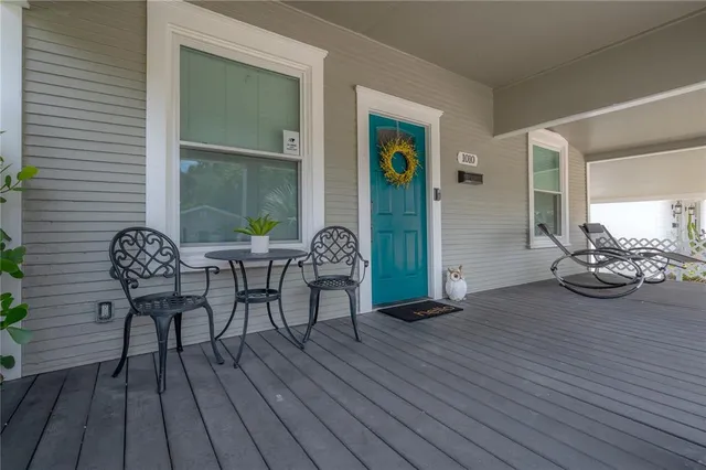 a view of a deck with table and chairs with wooden floor and potted plants