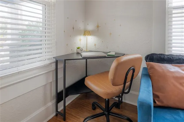 a view of a workspace with furniture and a window
