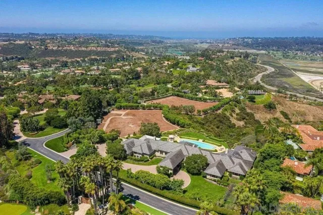 an aerial view of residential houses with outdoor space and trees