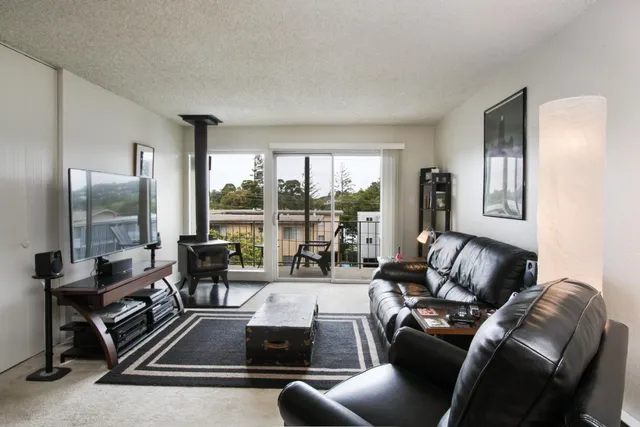 a living room with furniture and a floor to ceiling window