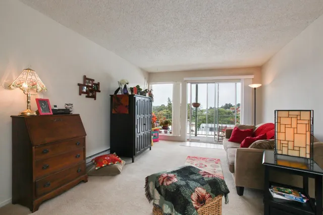 a bedroom with a bed and a dresser with wooden floor