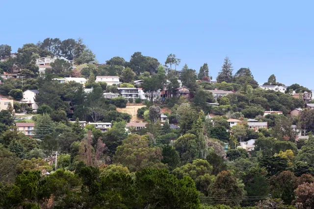 an aerial view of a house with swimming pool and mountains