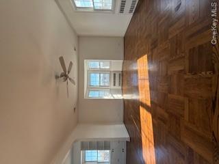 733 East Walnut Street, Unit UPPR Long Beach, NY 11561 - Photo 3 of 26 a view of empty room with wooden floor and fan