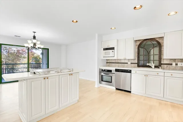 a kitchen with granite countertop white cabinets and white appliances