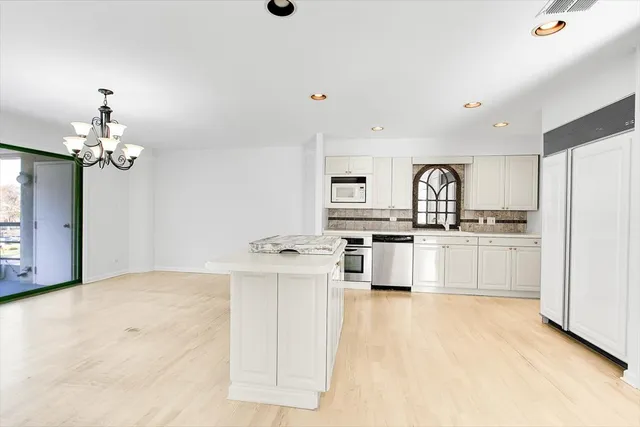 a kitchen with stainless steel appliances a white cabinets stove and refrigerator
