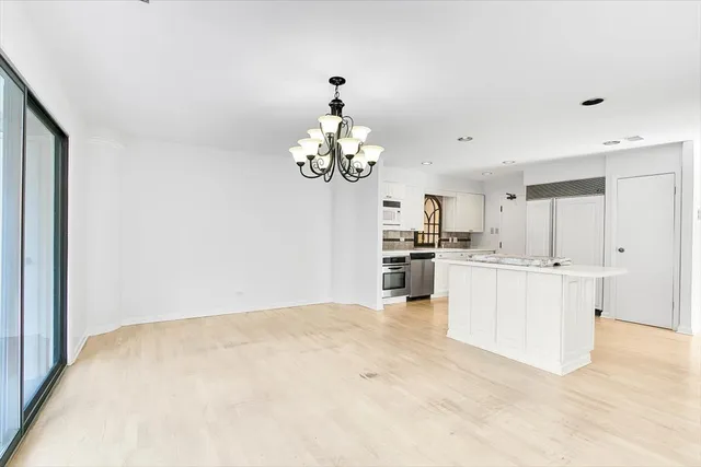 a kitchen with kitchen island white cabinets and stainless steel appliances