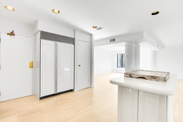 a view of kitchen with stainless steel appliances cabinets and wooden floor