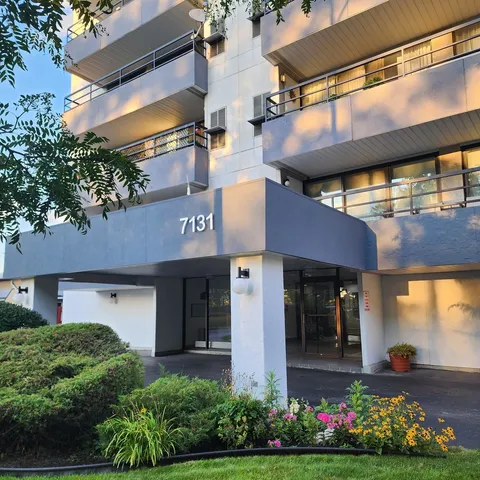 a view of a white house with large windows and a flower garden