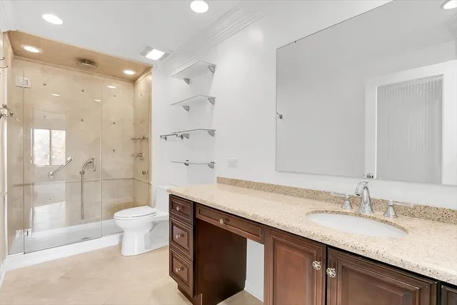 a bathroom with a granite countertop sink a toilet a mirror and shower