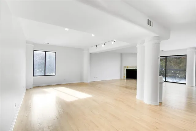 a view of empty room with wooden floor and windows