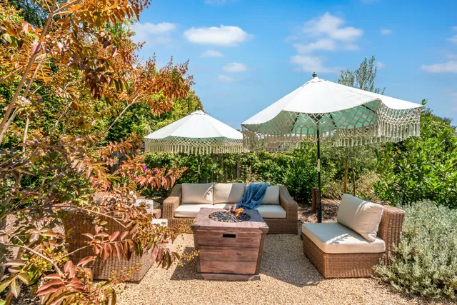 a view of a patio with furniture and a small yard