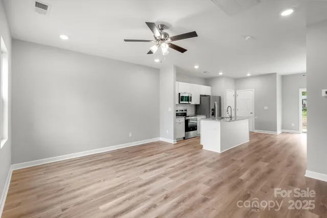 a view of a kitchen with furniture and wooden floor