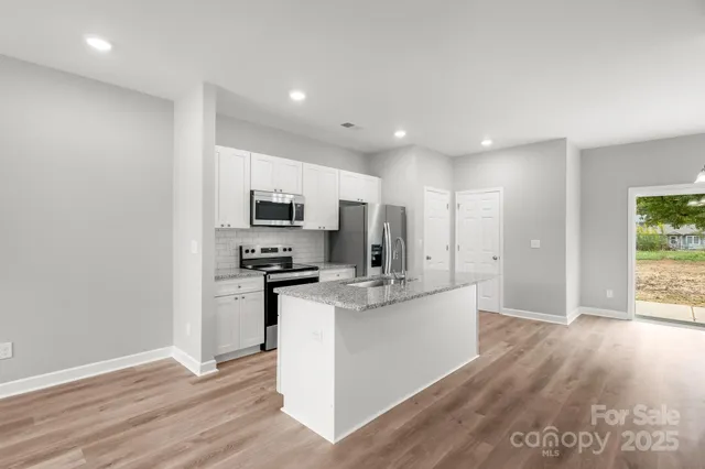 a kitchen with stainless steel appliances a refrigerator and a stove top oven