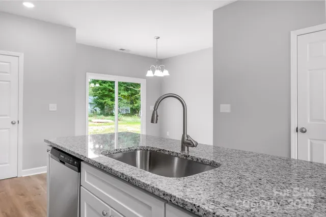 a kitchen with granite countertop a sink and a window