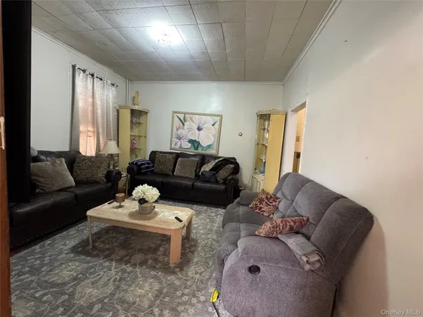 a living room with furniture couches and a dining table with wooden floor