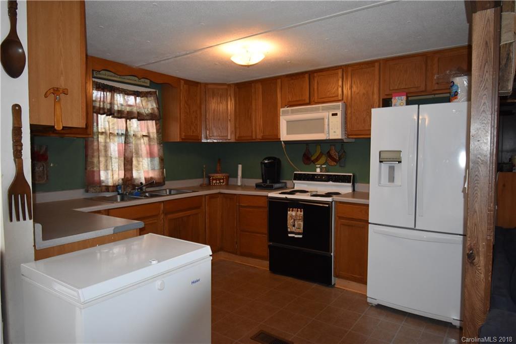 463 Lindsey Loop Road Fletcher, NC 28732 - Photo 16 of 27 a kitchen with a refrigerator a sink a stove and cabinets