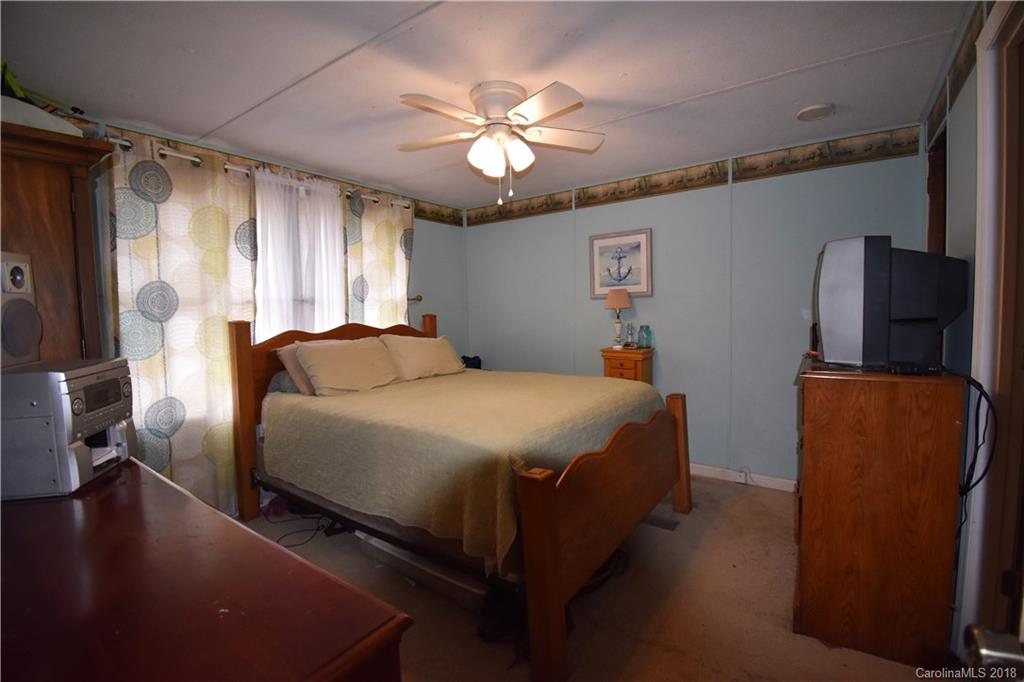 463 Lindsey Loop Road Fletcher, NC 28732 - Photo 18 of 27 a bed room with a bed and a chandelier