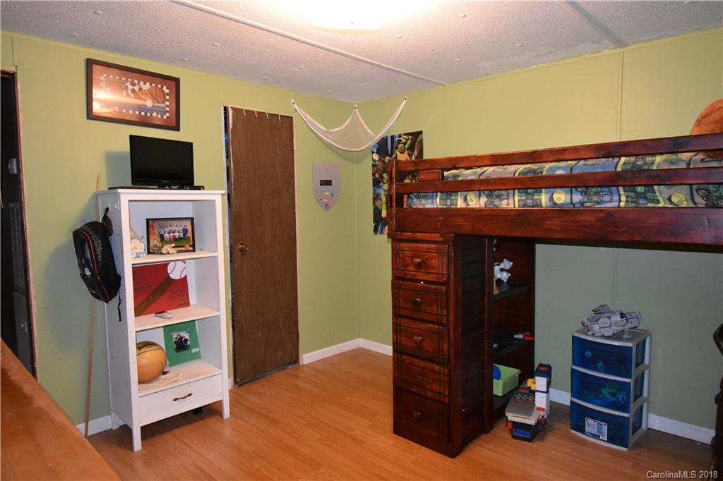 463 Lindsey Loop Road Fletcher, NC 28732 - Photo 23 of 27 a bedroom with a bed and a flat tv screen on dresser