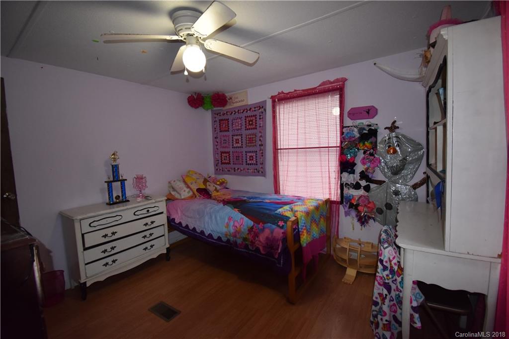 463 Lindsey Loop Road Fletcher, NC 28732 - Photo 26 of 27 a bedroom with a bed and a chandelier
