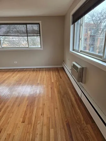 a view of a room with wooden floor and window