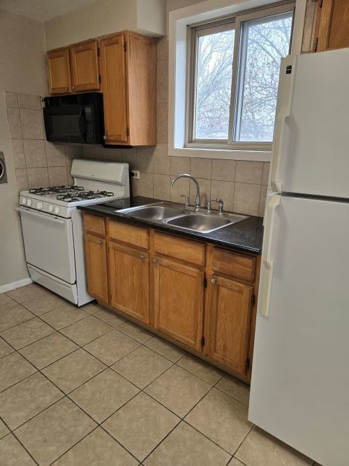 7019 North Ridge Avenue, Unit 3A Chicago, IL 60660 - Photo 7 of 11 a kitchen with a sink cabinets and a microwave