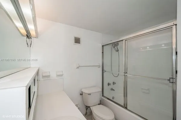 a bathroom with a shower toilet and sink