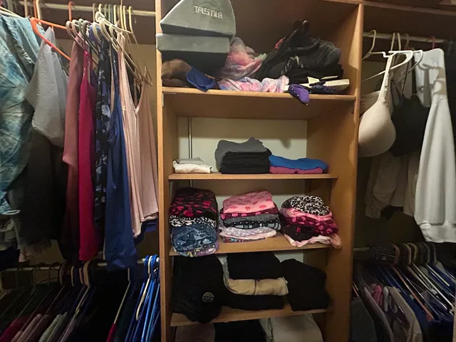 a view of walk in closet with clothes and shoes
