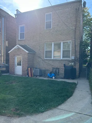 a brick house that has a garden in front of it
