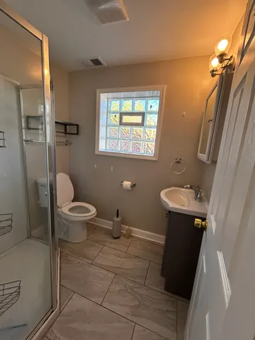 a bathroom with a sink a toilet and shower