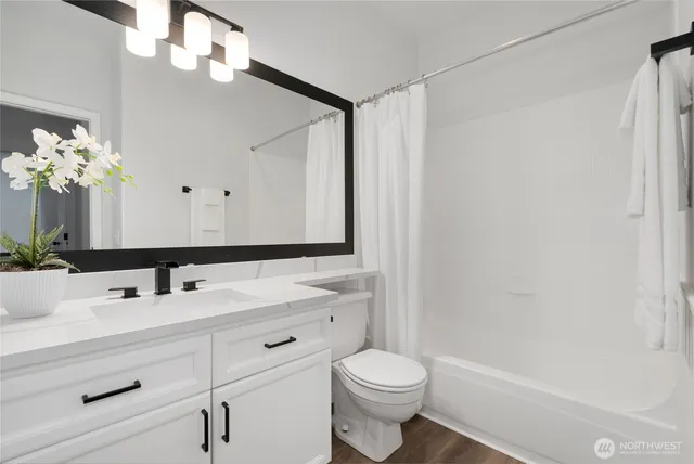 a bathroom with a sink a toilet a mirror and shower