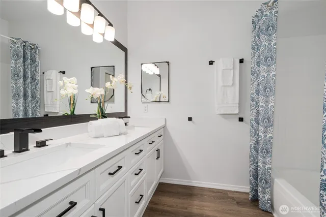 a bathroom with a double vanity sink mirror and shower