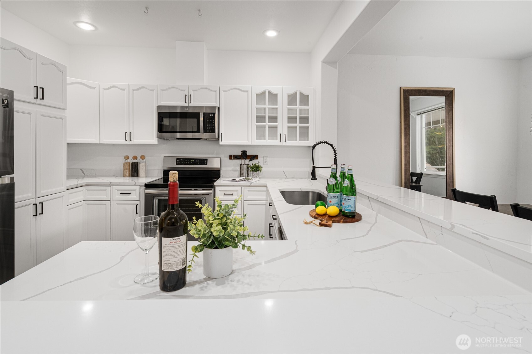 7583 Old Redmond Road, Unit A203 Redmond, WA 98052 - Photo 5 of 29 a kitchen with stainless steel appliances kitchen island granite countertop a sink white cabinets a stove top oven a dining table and chairs