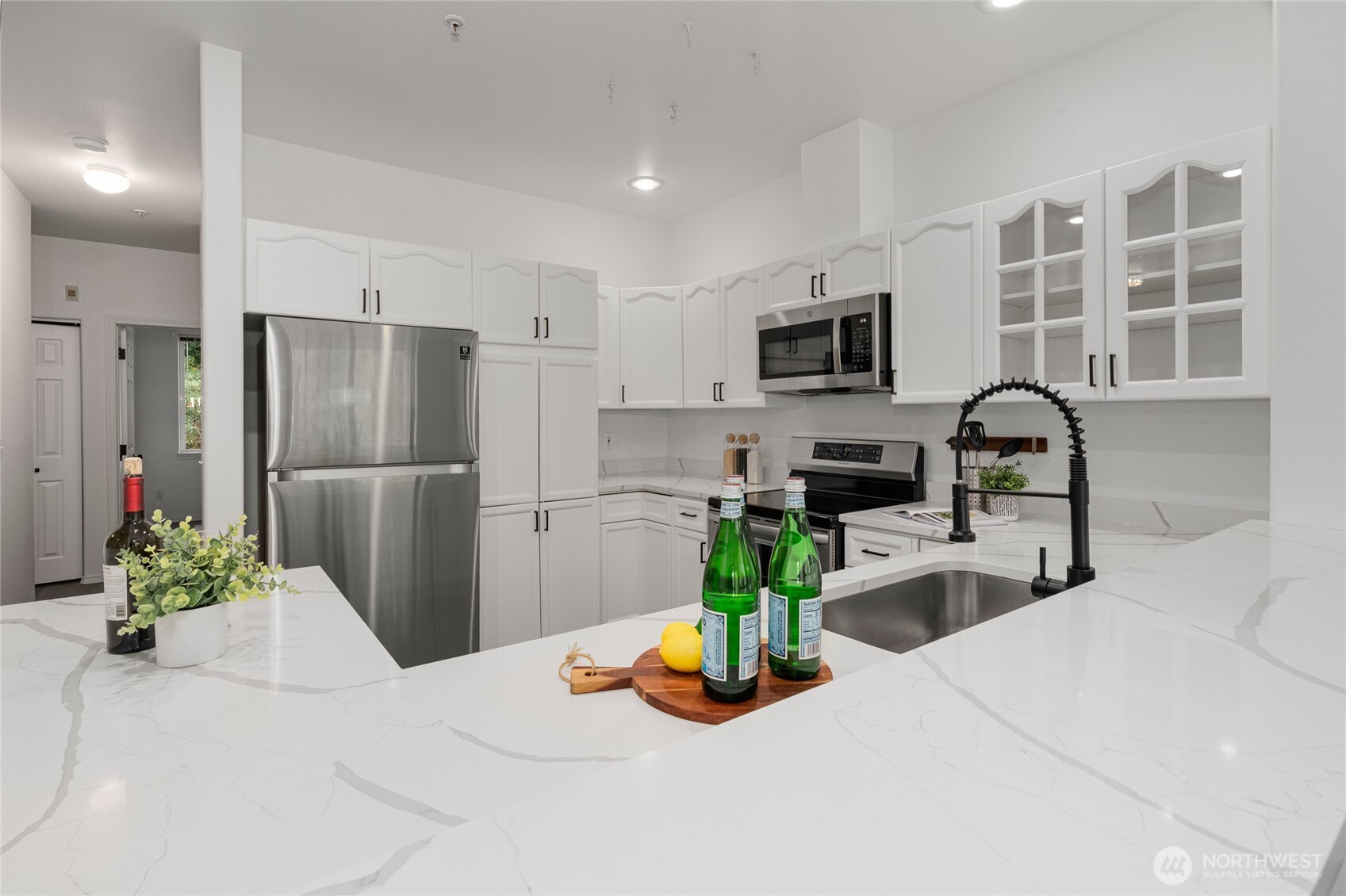 7583 Old Redmond Road, Unit A203 Redmond, WA 98052 - Photo 6 of 29 a kitchen with stainless steel appliances granite countertop a refrigerator a stove a sink a dining table and chairs