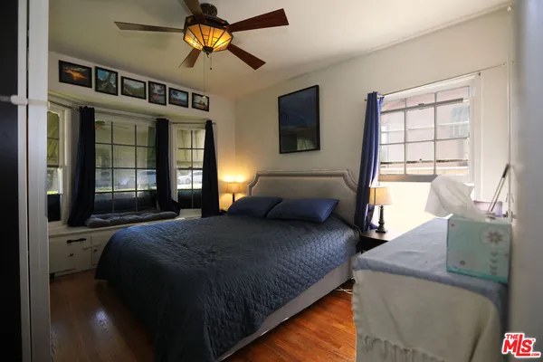 a bedroom with a bed and dresser with mirror