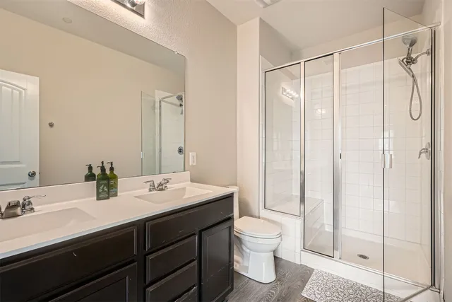 a bathroom with a double vanity sink toilet and shower