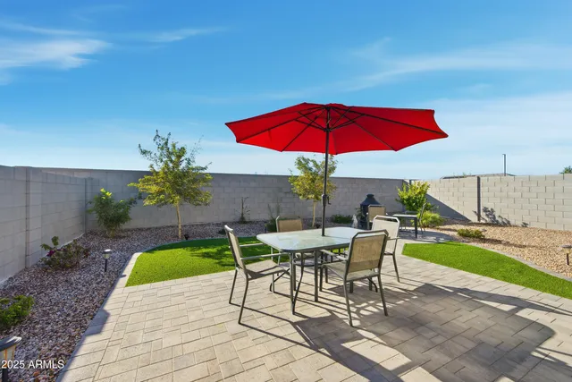 a view of patio with chairs and table under an umbrella