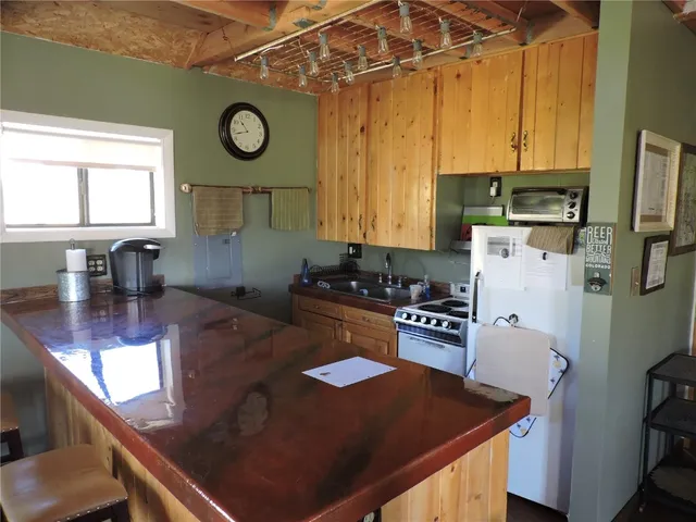 a kitchen with stainless steel appliances granite countertop a refrigerator a stove and a sink