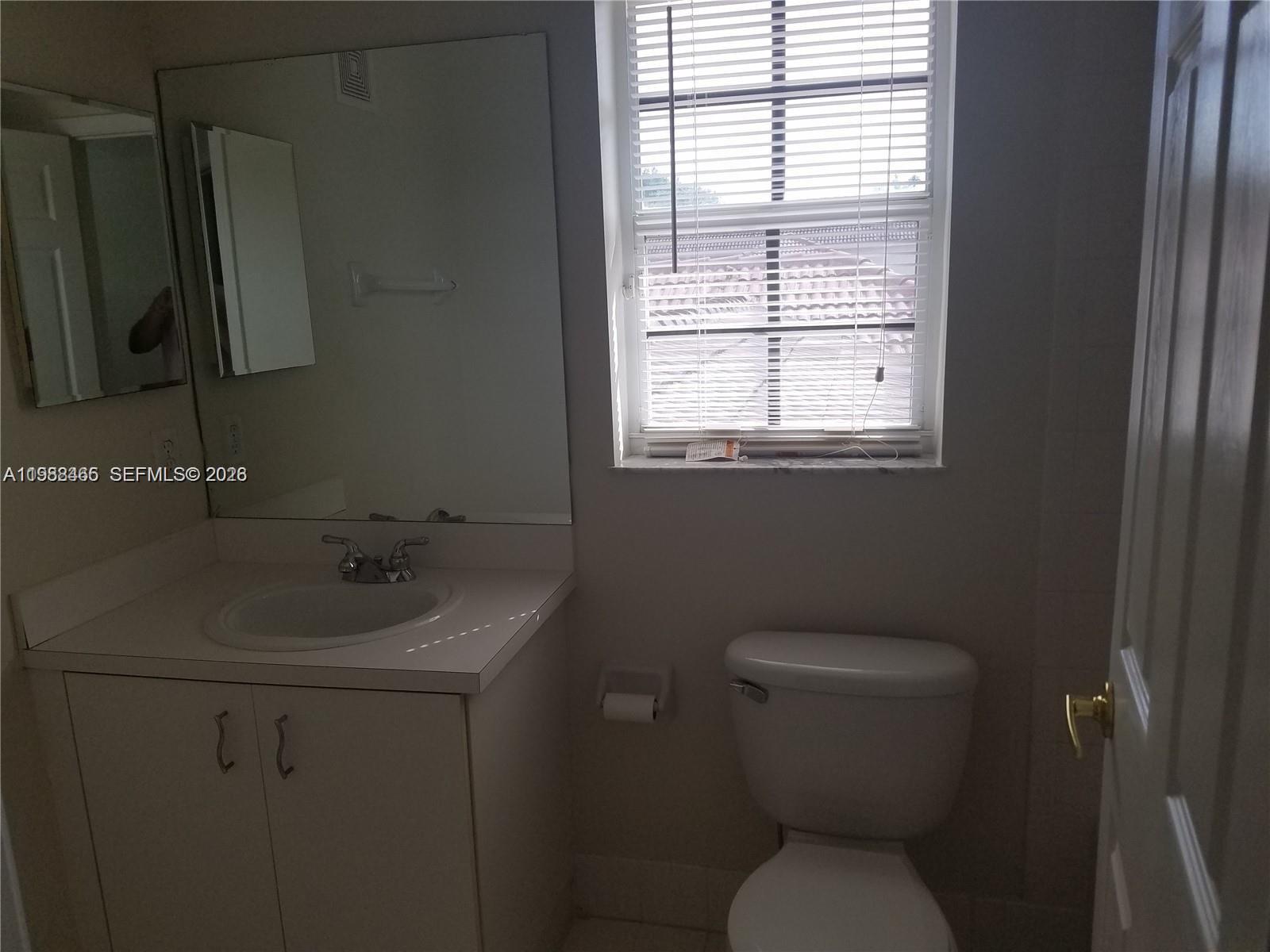18741 Southwest 25th Court Miramar, FL 33029 - Photo 17 of 32 a bathroom with a toilet sink and mirror